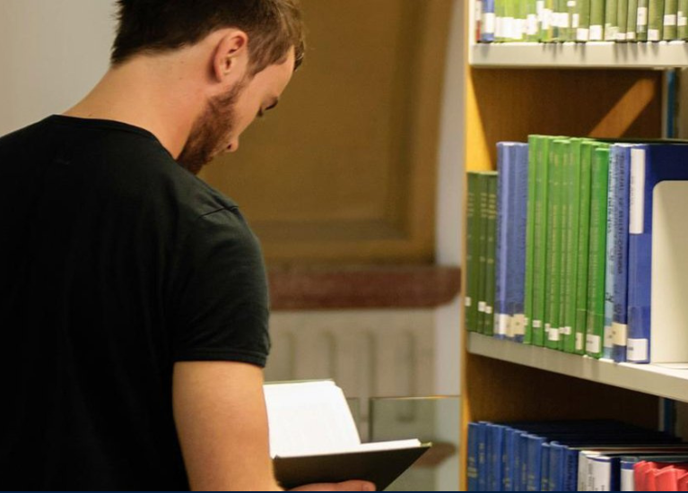 A student browsing books in a UCD library.